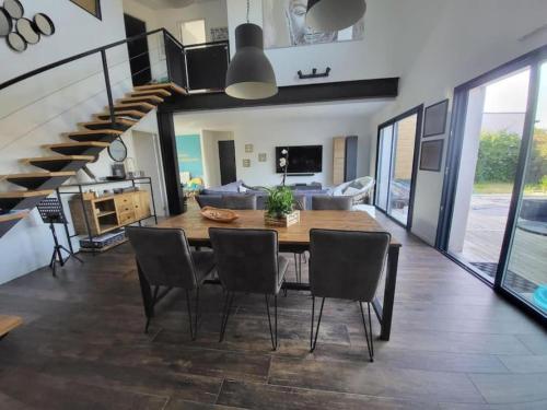 une salle à manger avec une table et des chaises et un escalier dans l'établissement Villa 4 chambres - 130m2 - 8 personnes, à Soustons