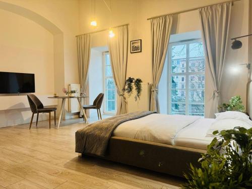a bedroom with a bed and a table and chairs at AbsyntApartments 24 Rynek Wrocław in Wrocław