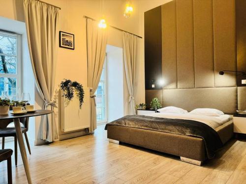 sypialnia z dużym łóżkiem i stołem w obiekcie AbsyntApartments 24 Rynek Wrocław we Wrocławiu