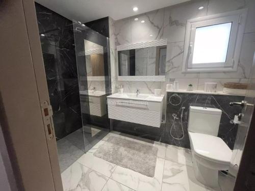 a bathroom with a toilet and a sink and a mirror at Seasonal Rental S2 at Folla Palm Lake Monastir in Monastir