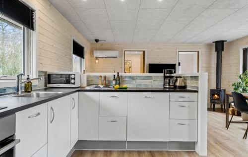 a kitchen with white cabinets and a stove at Three-Bedroom Holiday Home In Vestervig in Vestervig