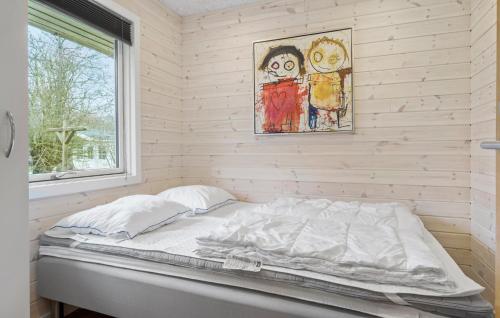 a bed in a room with a painting on the wall at Three-Bedroom Holiday Home In Vestervig in Vestervig