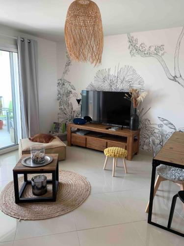 Il comprend un salon doté d'une télévision à écran plat. dans l'établissement T3 cosy - grande terrasse en accès direct à la mer, à Fleury