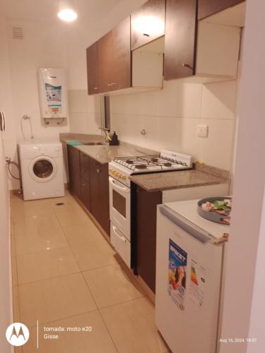 eine Küche mit einem Herd und einer Waschmaschine in der Unterkunft Departamento sobre AVENIDA con BALCON in Santiago del Estero