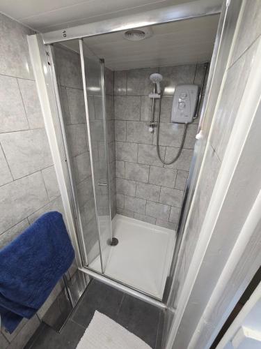 a bathroom with a shower with a blue towel at Gower Fresh Christmas Trees in Penclawdd
