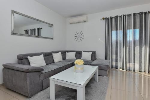 a living room with a couch and a table at Apartment Dijana with private pool in Donji Proložac