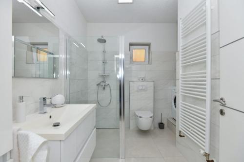 a white bathroom with a shower and a sink at Apartment Dijana with private pool in Donji Proložac