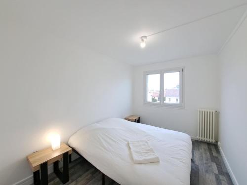 une chambre blanche avec un lit et une fenêtre dans l'établissement Sofia - Grand appartement, à Reims