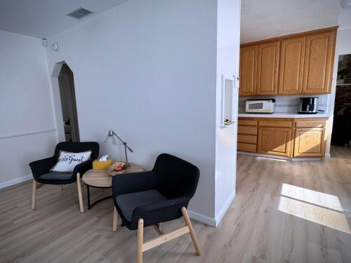 a living room with two chairs and a kitchen at gateway to the ocean in Hawthorne