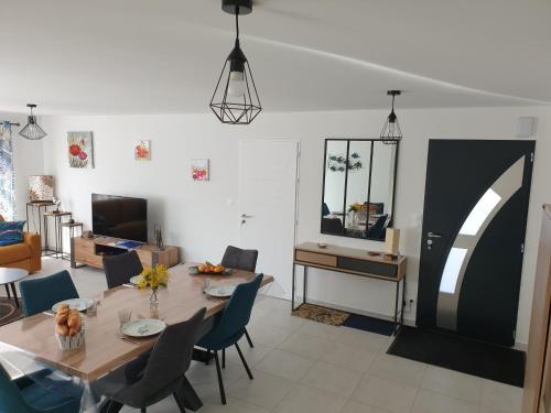 une salle à manger et un salon avec une table et des chaises dans l'établissement La Petite Californie, à La Tranche-sur-Mer