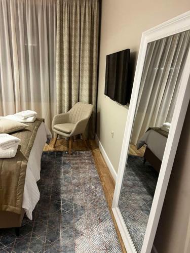 a mirror in a room with a bed and a chair at Stay Central in Ioannina