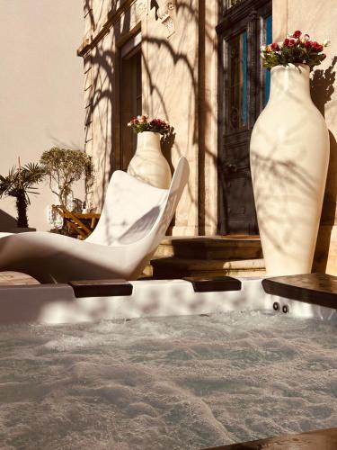 Deux grands vases blancs assis à côté d'un bâtiment dans l'établissement Villa Lepois & Spa 5 étoiles au cœur de Nancy, à Nancy