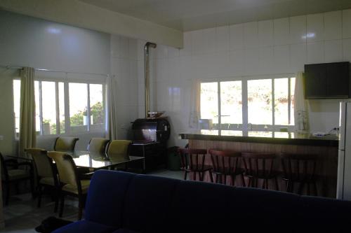a living room with chairs and a table and a tv at Casa de Campo Sol & Luz in Campina Grande do Sul