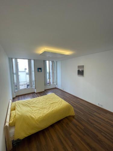 - une chambre avec un lit jaune dans une pièce dotée de parquet dans l'établissement Seemingly well placed 100m 2, à Paris