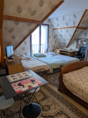 - une chambre avec 2 lits et une table avec un ordinateur portable dans l'établissement 3 Chambres-Disneyland Paris, à Saint-Thibault-des-Vignes