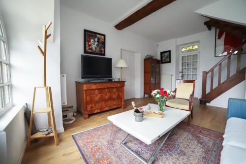 ein Wohnzimmer mit Tisch und Fernseher in der Unterkunft Chambres d'Hôtes avec piscine LA FESSARDIERE in Saint-Maurice-sur-Fessard