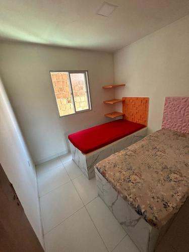 a small room with a bed and a window at Casa de praia Carneiros-Tamandaré in Tamandaré