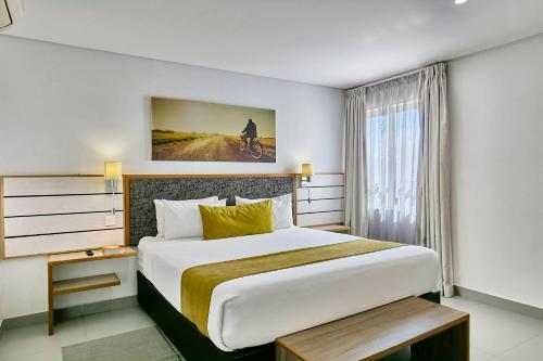 a hotel room with a large bed and a window at Travelodge in Gaborone