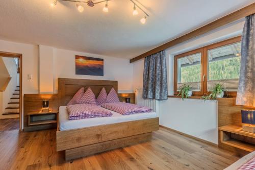 a bedroom with a bed with purple pillows at Ferienhaus Tirol im Ötztal in Umhausen