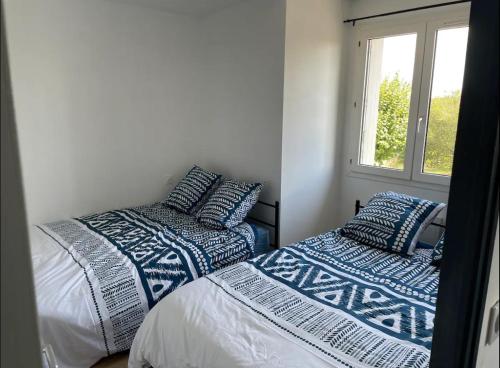 une chambre avec deux lits et une fenêtre dans l'établissement Appartement T2 proche du futuroscope, à Poitiers