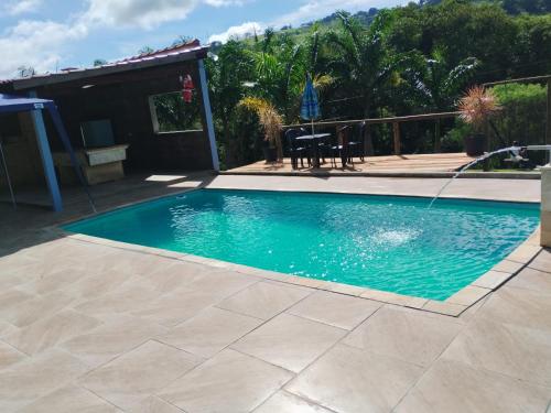 una piscina con acqua blu in un cortile di Chácara Sonho Verde a Bueno Brandão