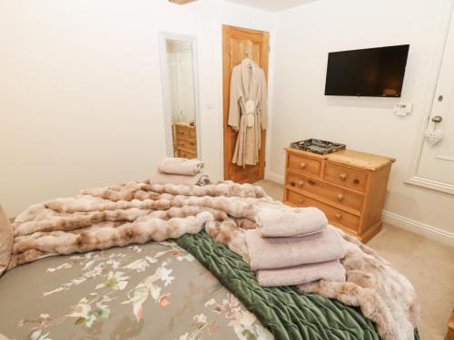 een slaapkamer met een bed met een stapel handdoeken erop bij River Dance Cottage in Leyburn