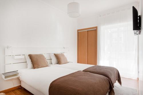a bedroom with a large bed and a window at Luz & Mar at Coastal Oeiras in Oeiras