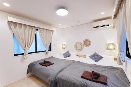 ein Schlafzimmer mit einem Bett, auf dem zwei braune Handtücher liegen in der Unterkunft European villa in Tokio