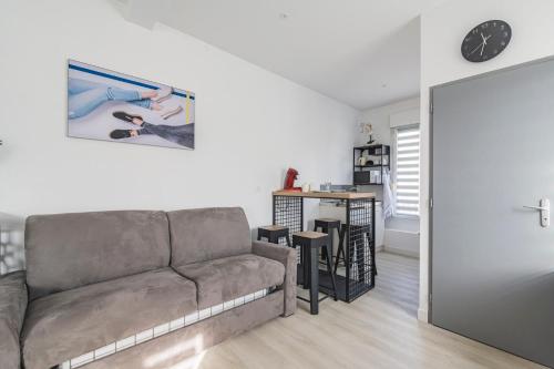 un salon avec un canapé et une table dans l'établissement Le refuge, tout confort avec climatisation, à Cormontreuil