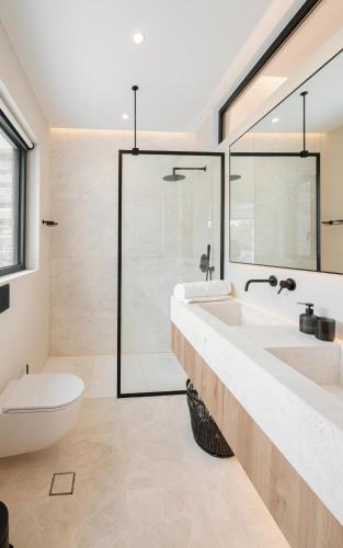 a bathroom with two sinks and a shower at Elia Cove Luxury Villa II in Loutraki