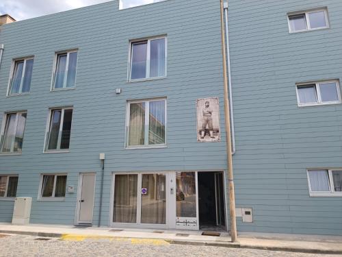 un edificio blu con un cane su un lato di Cachinnans Hostel & Apartments a Vila do Conde
