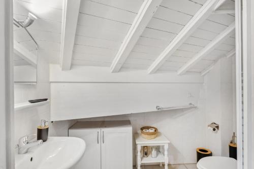 a white bathroom with a sink and a toilet at Triplex in Villars Centre with Parking - Totally Renovated in Villars-sur-Ollon