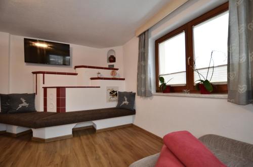 a living room with a couch and a stair case at Ferienhaus Tirol im Ötztal in Umhausen