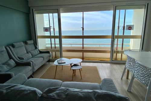 un salon avec un canapé et une table dans l'établissement Grand appartement vue mer panoramique, à Étretat