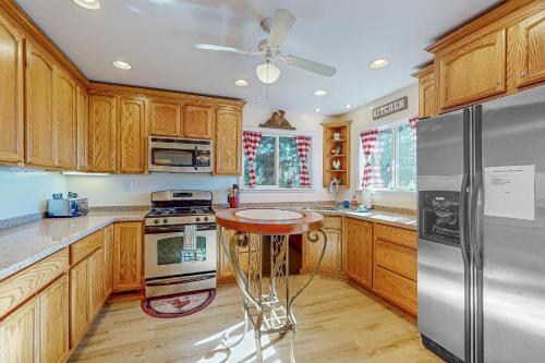 a kitchen with wooden cabinets and a stainless steel refrigerator at Tree-mendous Skypark-View Cabin in Skyforest