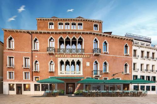 a large brick building with tables in front of it at Hotel Gabrielli Venezia - Starhotels Collezione in Venice