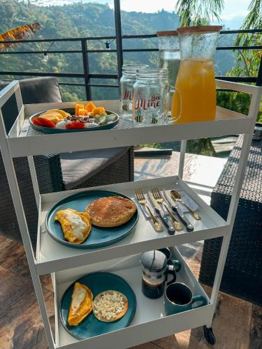 a table with plates of breakfast food and a drink at Le Jardin d A in Santa Bárbara