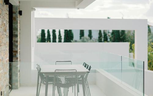 a dining room with a table and four chairs at Elia Cove Luxury Villa II in Loutraki