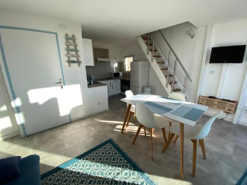 une cuisine et une salle à manger avec une table et des chaises dans l'établissement Joli Duplex résidence Atlantis accès direct plage, au Barcarès