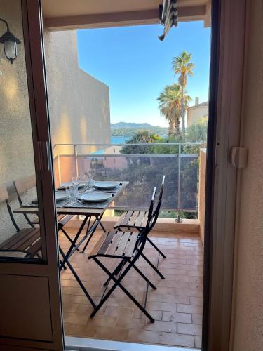 un patio avec une table et des chaises sur un balcon dans l'établissement Tout proche de la plage, à 12 min à pied du port, place de parking, à Bandol
