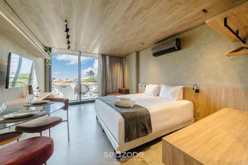 a bedroom with a bed and a table and a desk at NWTs - Estúdios em Prédio com Vista Mar in Maceió