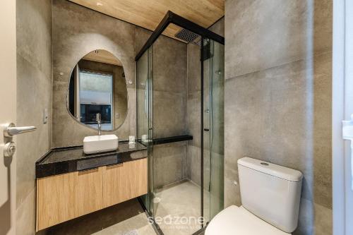 a bathroom with a toilet and a sink and a mirror at NWTs - Estúdios em Prédio com Vista Mar in Maceió