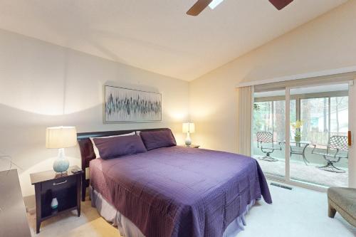 ein Schlafzimmer mit einem lila Bett und einem Fenster in der Unterkunft 22 Harpoon rd in Ocean Pines