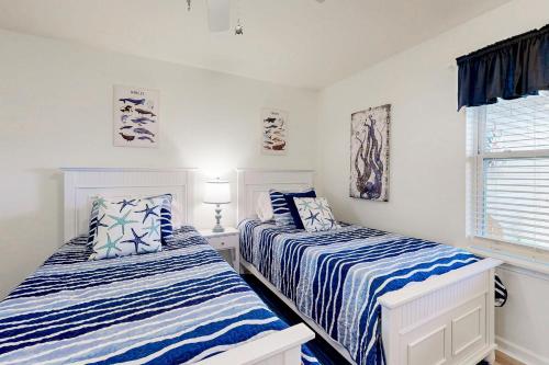 a bedroom with two beds with blue and white sheets at Bethany Bay --- 37460 Pettinaro Dr #6801 in Ocean View