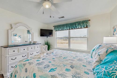 a bedroom with a bed and a dresser and a mirror at Bethany Bay --- 37460 Pettinaro Dr #6801 in Ocean View