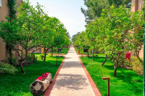 a walkway in a park with trees and grass at Pirate's Beach Club -Ultra All Inclusive in Tekirova