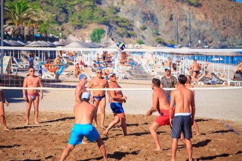 a group of men playing a game of volleyball on the beach at Pirate's Beach Club -Ultra All Inclusive in Tekirova