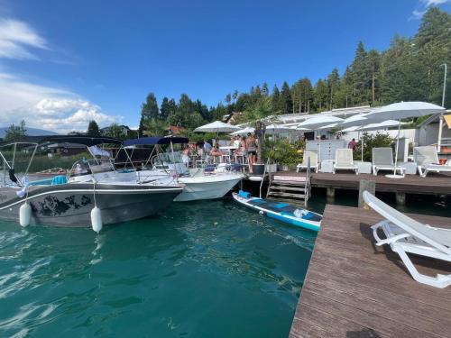 two boats are docked at a dock in the water at Ville Bianche in Drobollach am Faakersee