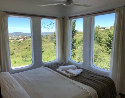 a bedroom with two towels on a bed with two windows at El Faro de Carpier - ApartHotel & Restaurante Bar Cafetería in Tanti