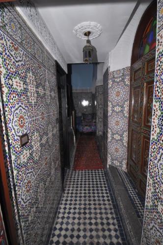a hallway with tiles on the walls of a room with a carpet at Riad Khouloud in Fès